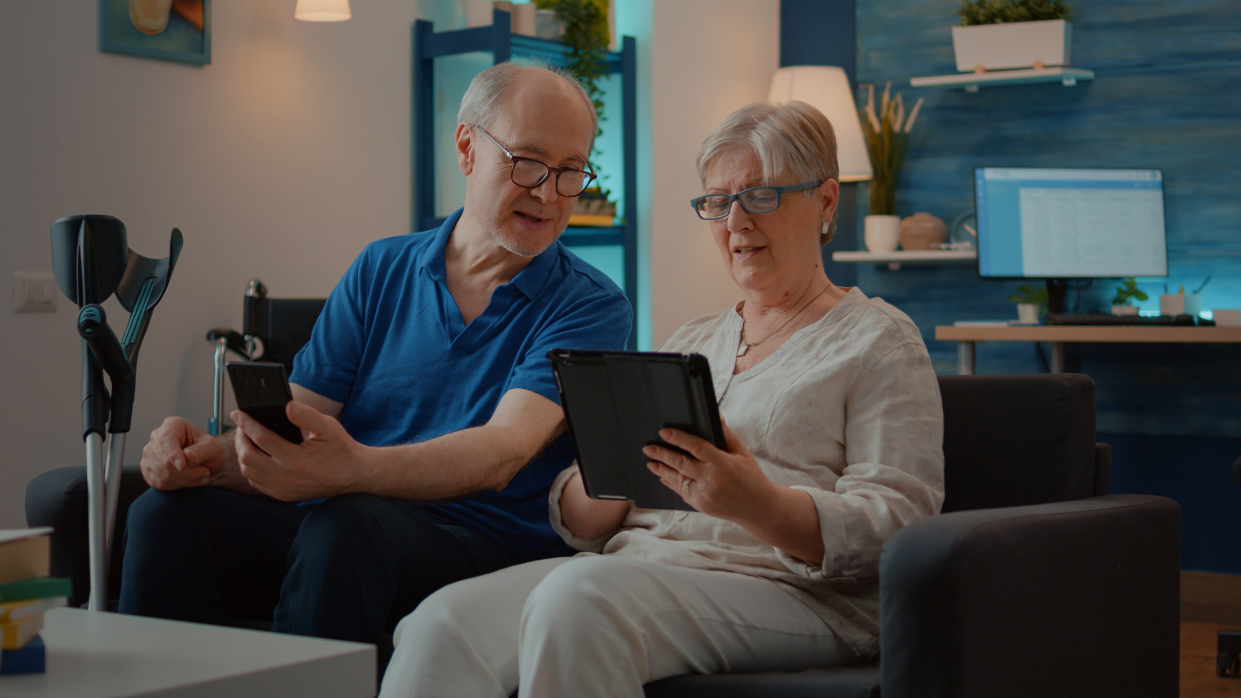 grandparents using smartphone digital tablet home enjoying technology free time man with disability looking mobile phone screen starting conversation with wife scaled